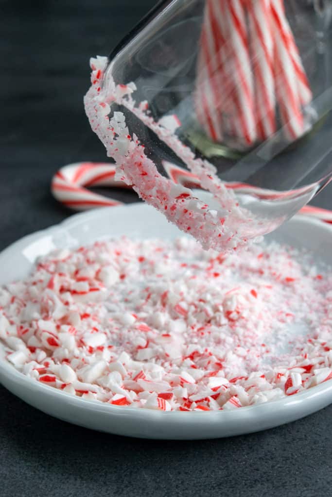 Dipping rim of glass in crushed peppermint candy.