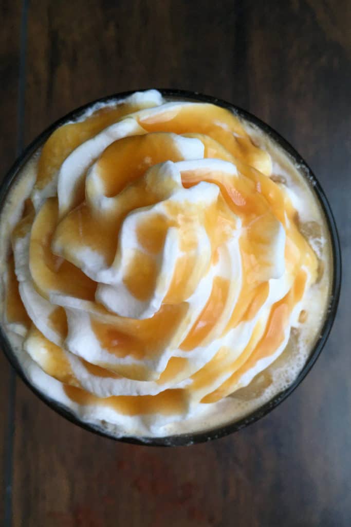 overhead picture of thick ribbons of starbucks whipped cream drizzled with caramel sauce