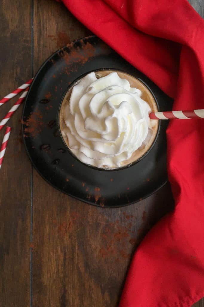 overhead picture of iced coffee with big dollop of whipped cream on top