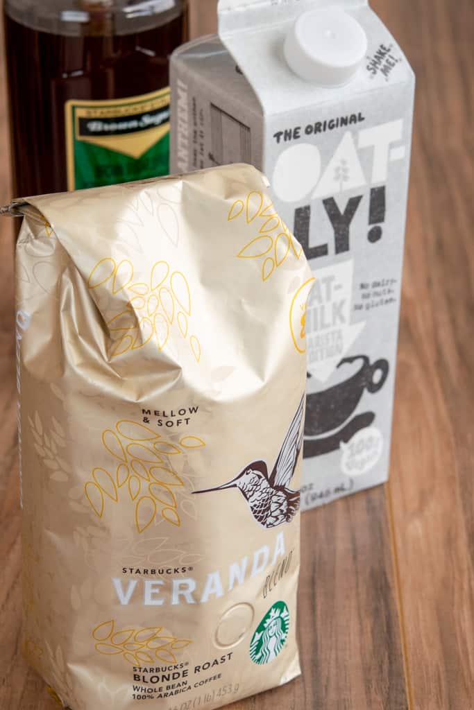 Bag of Starbucks Veranda blonde roast coffee beans, carton of milk and bottle of Starbucks brown sugar syurp.