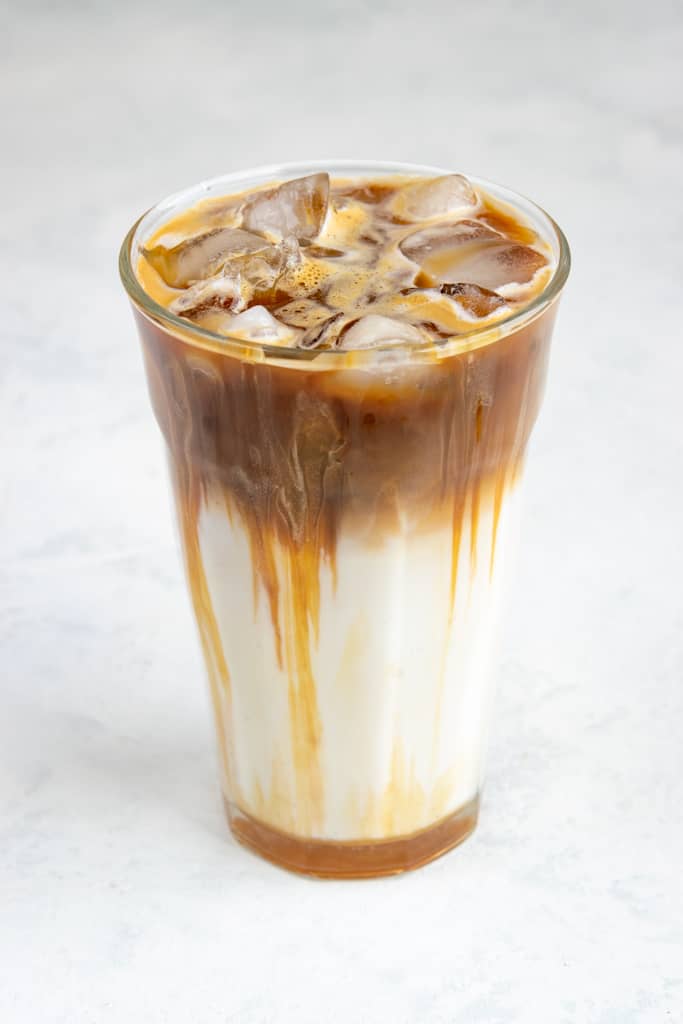 Iced caramel macchiato with layer of caramel, espresso, milk and ice.