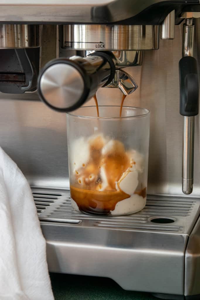 Making an affogato by pulling espresso shot directly on top of vanilla gelato.