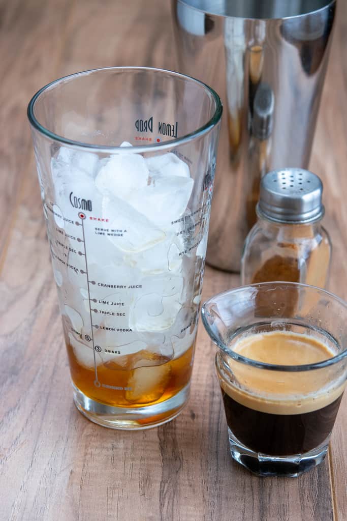 Espresso in shot glass about to be poured into shaker to make a homemade Starbucks iced brown sugar shaken espresso.