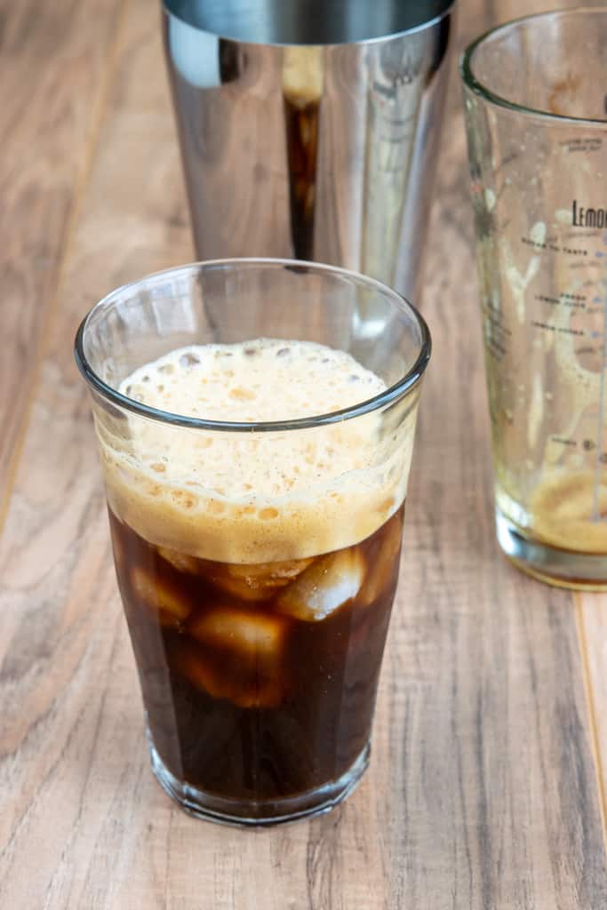 Iced Shaken Espresso Starbucks copycat drink poured into glass with lots of foam on top.