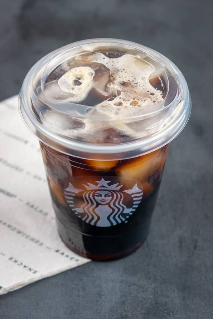 Starbucks cold brew in cup with lid sitting on napkin.