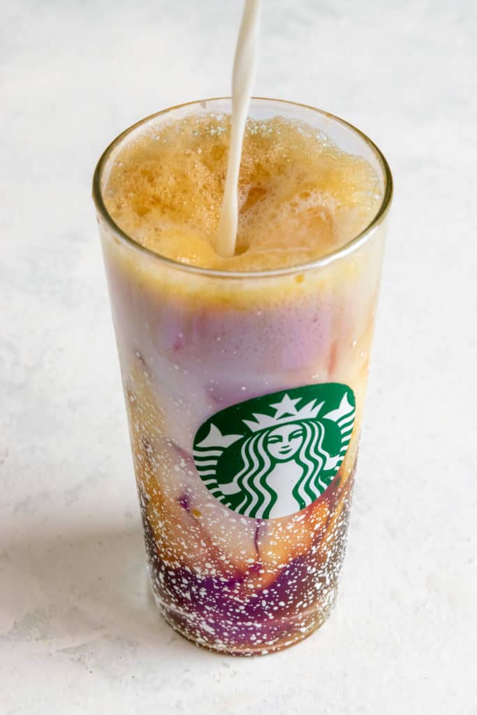 Pouring milk into Starbucks copycat Iced Shaken Espresso.