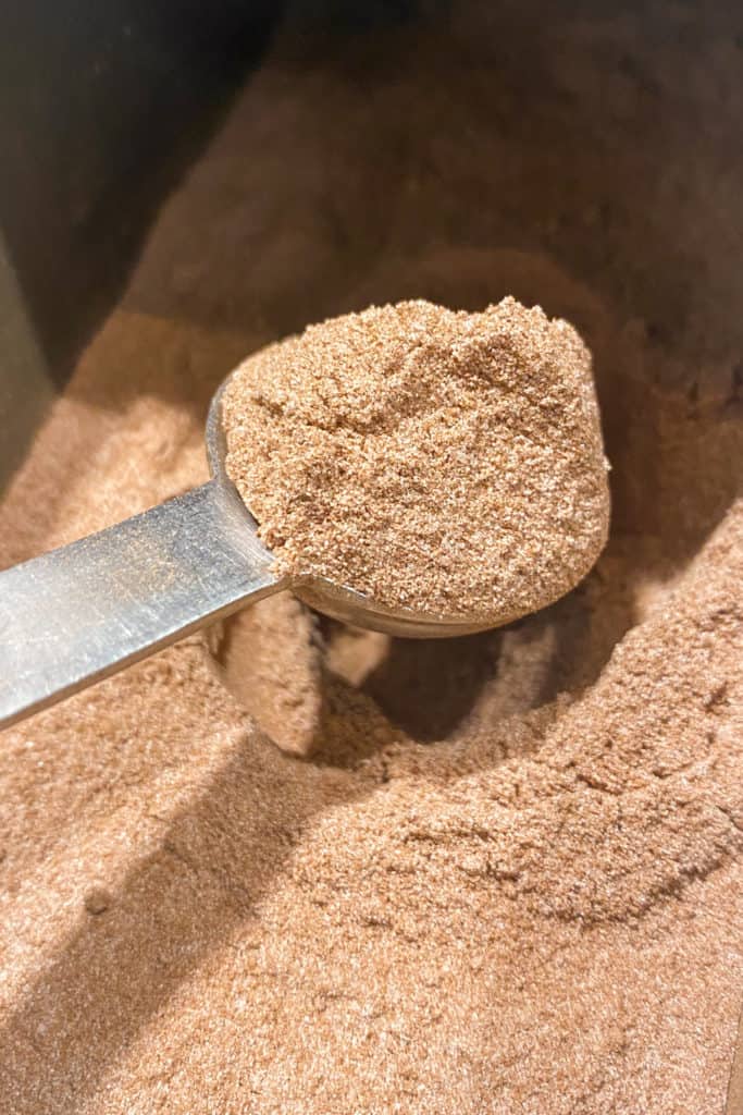 Starbucks barista scooping chocolate malt powder.