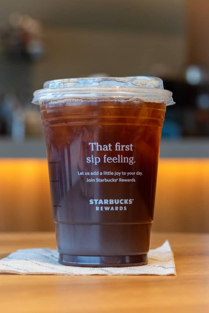 Starbucks Iced Americano on a napkin inside a Starbucks store.