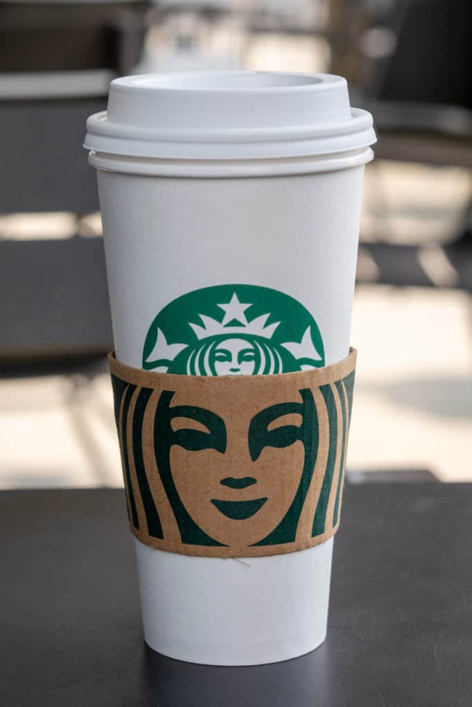 Starbucks hot tea in a double cup with sleeve.