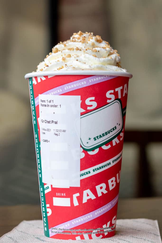 Chestnut Praline Latte in a Starbucks red cup with order sticker on it.