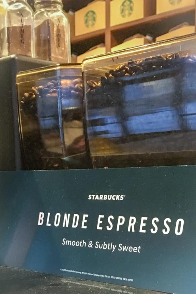 Starbucks blonde espresso sign on top of espresso machine inside Starbucks.