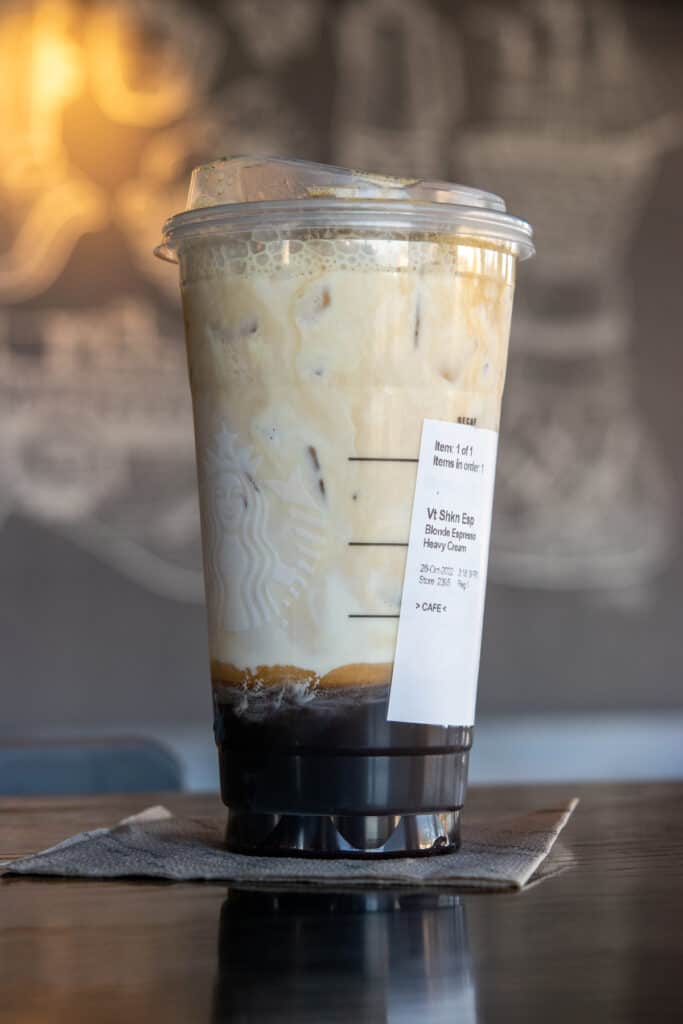 A venti Starbucks iced shaken espresso with label showing it's made with blonde espresso and heavy cream.