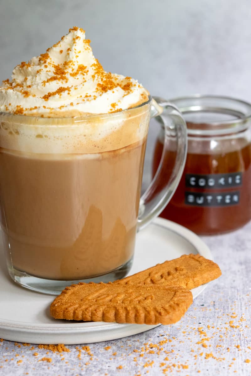 Biscoff cookie butter latte, jar of homemade cookie butter syrup and two Lotus Biscoff cookies.