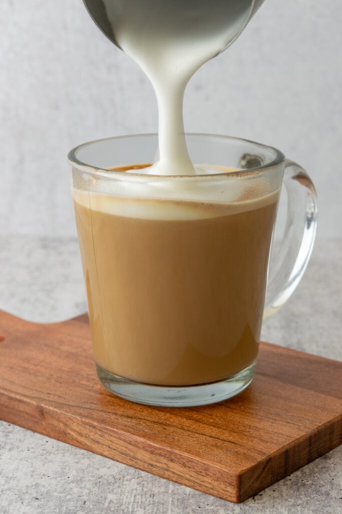 Steamed milk being poured into a maple latte.