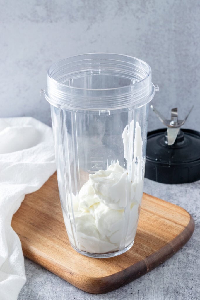 Blender cup with yogurt in it.